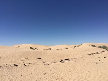 Scenic view of desert against clear blue sky