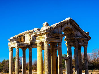 Old ruin temple of aphrodite against clear blue sky