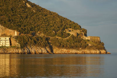 Scenic view of sea and mountains against sky