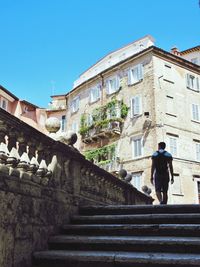Rear view of man walking on steps