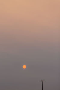 Low angle view of silhouette communications tower against sky during sunset