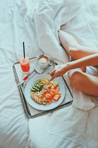 Midsection of woman having breakfast on bed