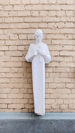 Statue of cross against wall