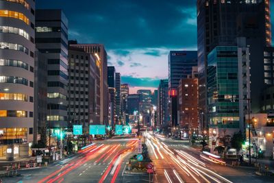 Traffic on city street amidst buildings at night