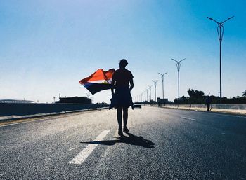 Rear view of man standing on road