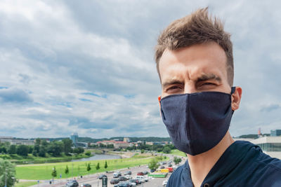 Portrait of young man against sky