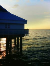 Pier on sea at sunset