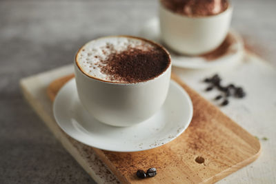 Close-up of coffee cup on cutting board