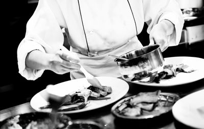 Midsection of man preparing food in restaurant