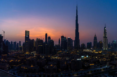 Aerial view of buildings in city at sunset