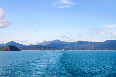 Scenic view of sea by mountains against sky