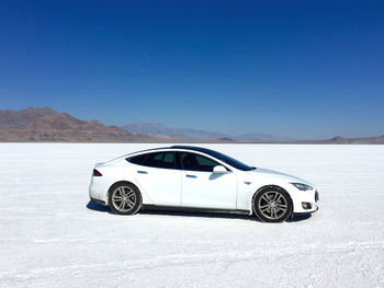 View of car on mountain road against clear blue sky