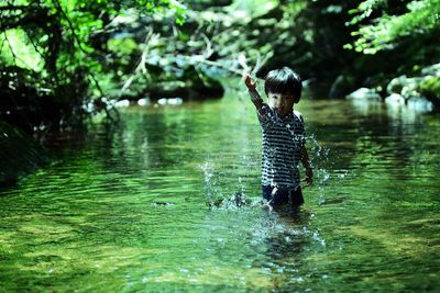 Portrait of boy standing in river