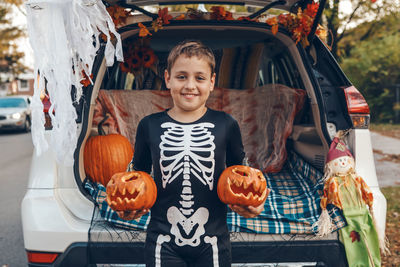 Portrait of smiling boy with pumpkins in market
