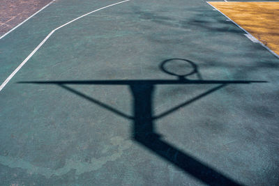 Street basketball hoop shadows on the court