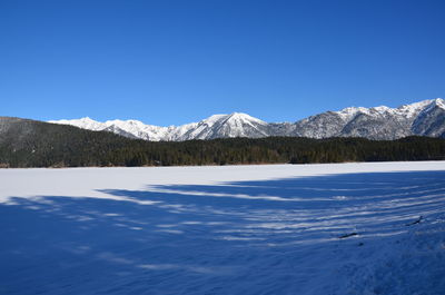 Scenic view of snowcapped mountains against clear blue sky