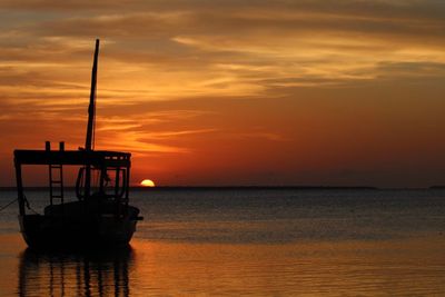 Silhouette ship in sea against sky during sunset