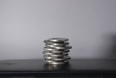 Close-up of coin on table against wall