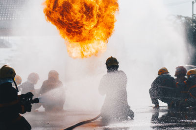 Rear view of firefighters extinguishing fire