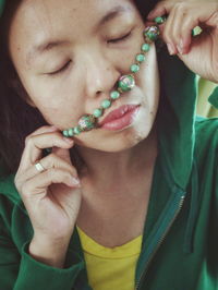 Close-up of woman holding bead necklace