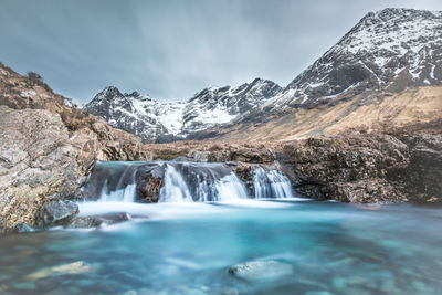 Scenic view of waterfall against sky