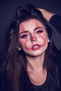 Portrait of a beautiful young woman over black background