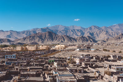 Aerial view of townscape against blue sky