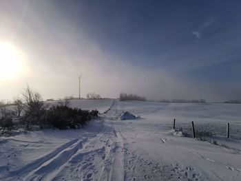 Scenic view of snow covered field against sky