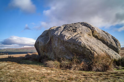 View of rock on field against sky