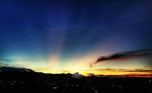 Silhouette cityscape against sky during sunset