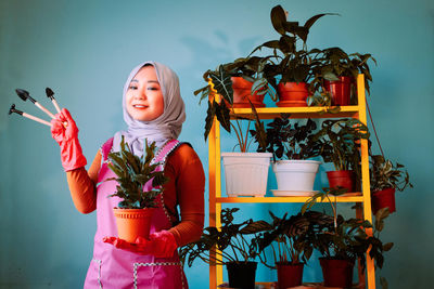 Full length of girl holding potted plant
