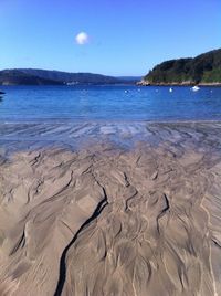 View of calm beach against blue sky