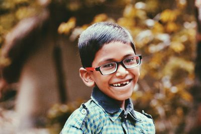 Portrait of smiling boy wearing eyeglasses outdoors