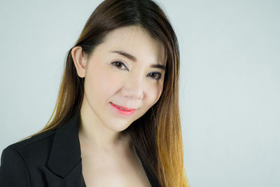 Portrait of smiling woman against white background