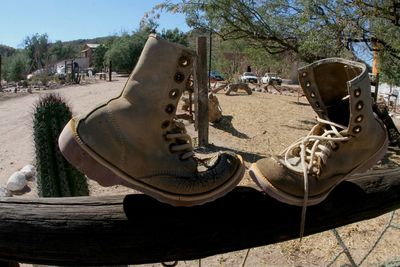 Close-up of old shoes on sand