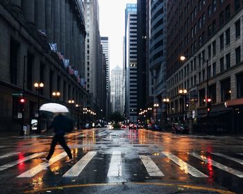 Man crossing city street during rain