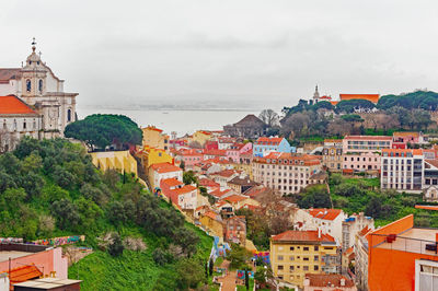 High angle view of townscape by sea against sky