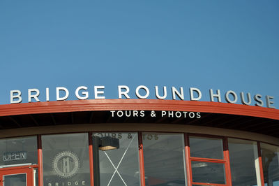 Low angle view of information sign against clear sky