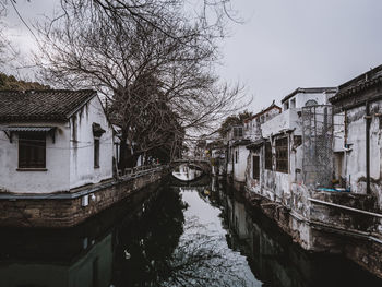 Canal amidst buildings against sky