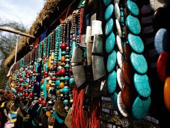 Close-up of multi colored umbrellas hanging against sky