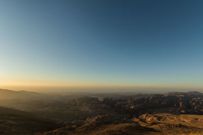 Scenic view of landscape against clear sky during sunset