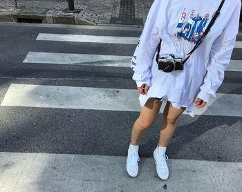 Low section of woman standing on street