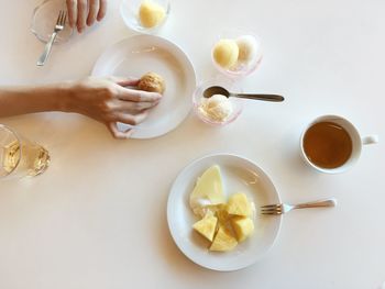 Cropped image of person holding food in plate on table