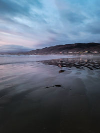 Scenic view of beach against sky during sunset