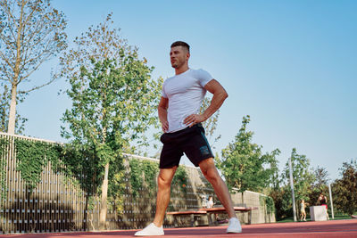 Full length of woman exercising on field