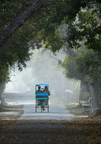 Rear view of man riding motorcycle on road