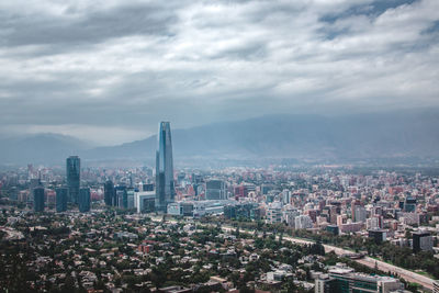 View of cityscape against cloudy sky