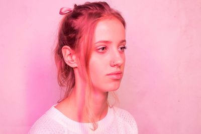 Portrait of beautiful young woman over pink background