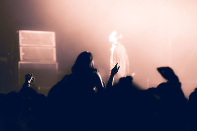 Silhouette people photographing at music concert