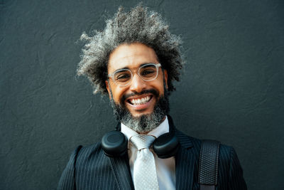 Portrait of young man standing against wall